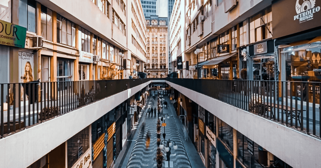Vista da arquitetura a céu aberto da Galeria Nova Barão no Centro de São Paulo. A foto mostra o piso inferior com calçamento ondulado de pedras portuguesas e o piso superior, conhecido como Rua Alta, com destaque para a fachada da loja de discos de vinil Petróleo Music.